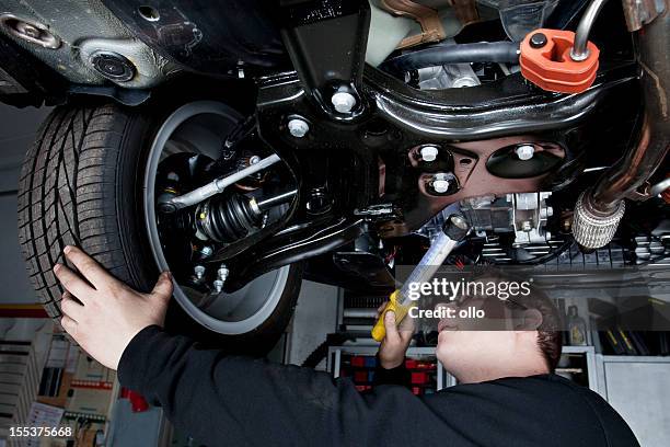 mechanic is checking the shock absorbers of a modern car - shock absorber stock pictures, royalty-free photos & images