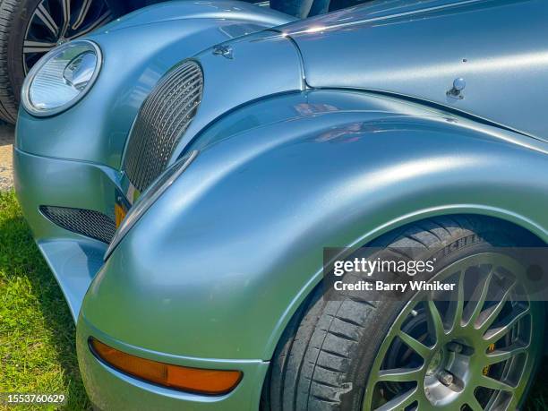 looking down at blue exterior finish and curved design of front grille of parked morgan aero 8 convertible sports car, copake - morgan aero 8 stock pictures, royalty-free photos & images