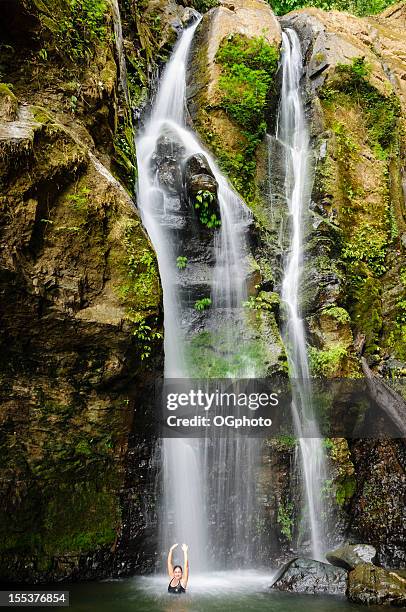 a woman relaxing and bathing under a waterfall - costa rica women stockfoto's en -beelden