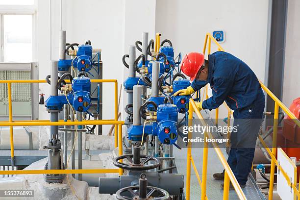 engineer in protective wear checking oil pipes equipment - chemical plants stock pictures, royalty-free photos & images