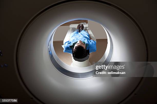 mann mit einer medizinischen untersuchung über magnetresonanztomographie - pet tomograph stock-fotos und bilder