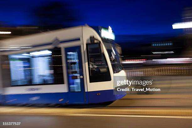 tram at night with panning motion in amsterdam - cable car stockfoto's en -beelden