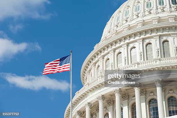 american flag waving in front of capitol hill - capital hill stock pictures, royalty-free photos & images