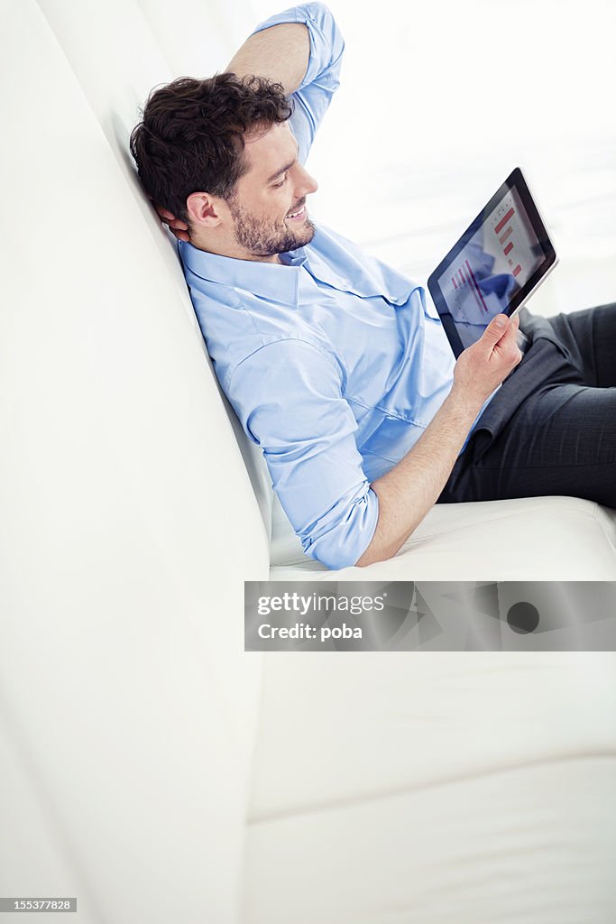 Relaxed businessman using digital tablet in office