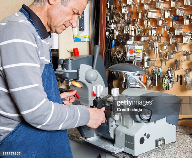 locksmith at work....making spare key - locksmith stockfoto's en -beelden