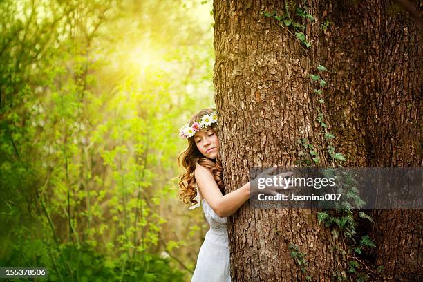 young woman hugging a tree - tree forest flowers stockfoto's en -beelden