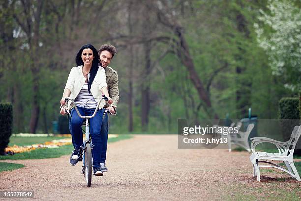 couple in the park - tandem bike stock pictures, royalty-free photos & images