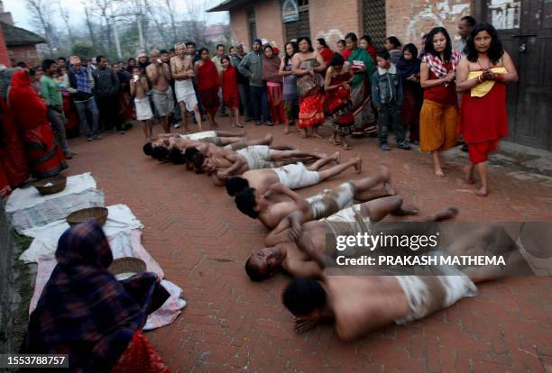 Nepalese Hindu devotees offer prayers by rolling on the ground after performing a bathing ritual on the last day of the month-long Swasthani Festival...