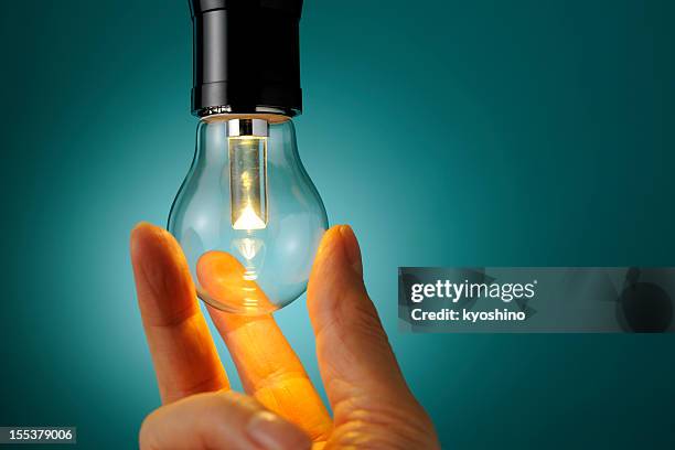 hands exchange old tungsten bulb to low power consumption led - resourceful bildbanksfoton och bilder
