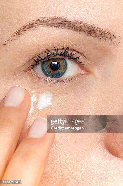 skin care woman putting face cream - putting lotion stock pictures, royalty-free photos & images