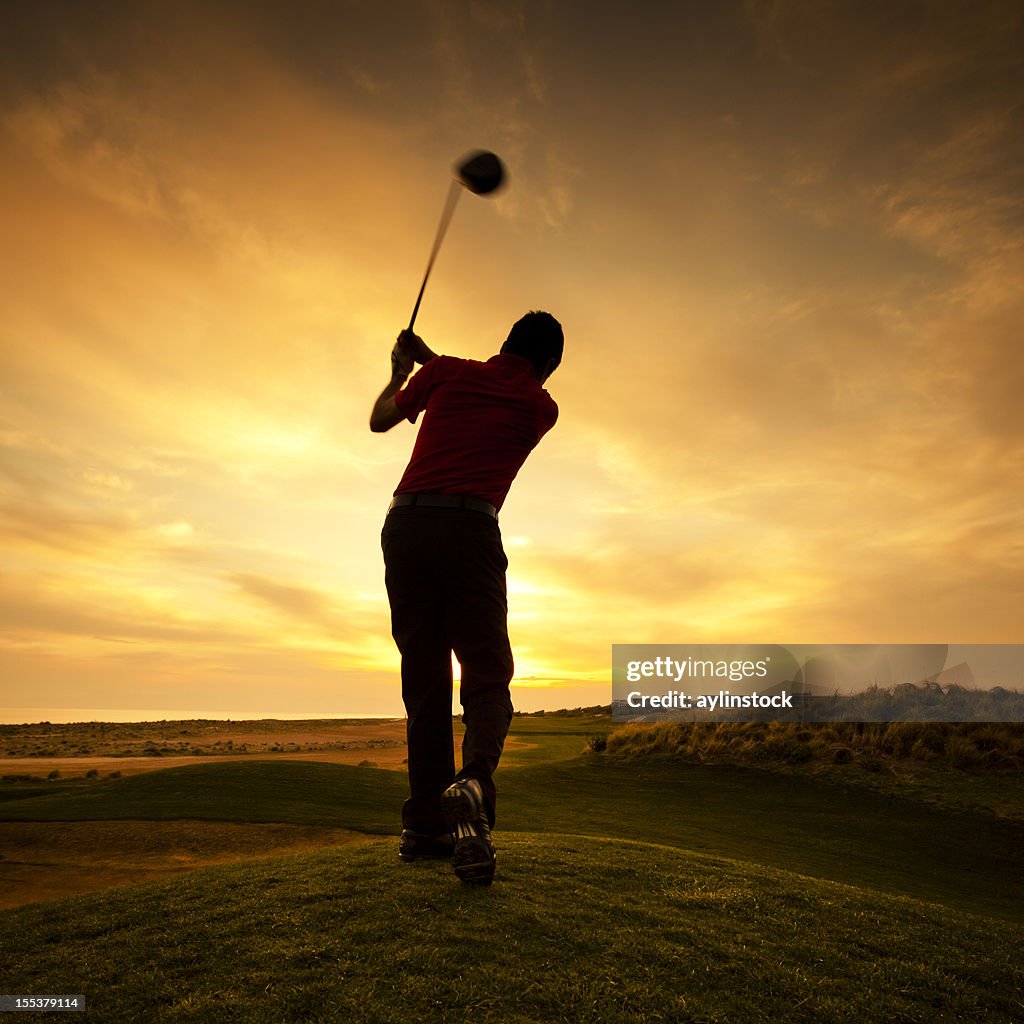 Silhouette of golfer during sunset