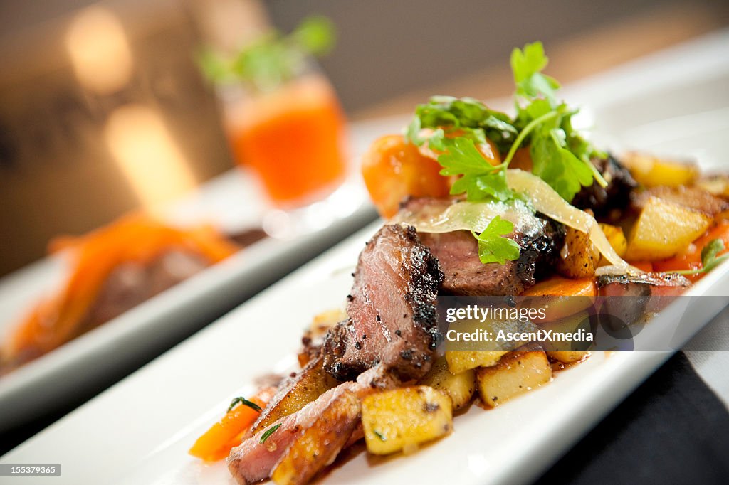 Roasted duck slices served with potatoes and carrots