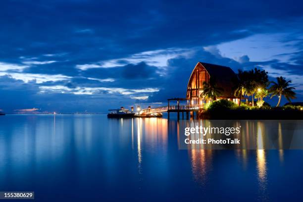 the tranquil night and beautiful seascape of maldives - beach hut stock pictures, royalty-free photos & images