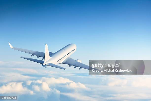 commercial jet flying over clouds - air travel stock pictures, royalty-free photos & images