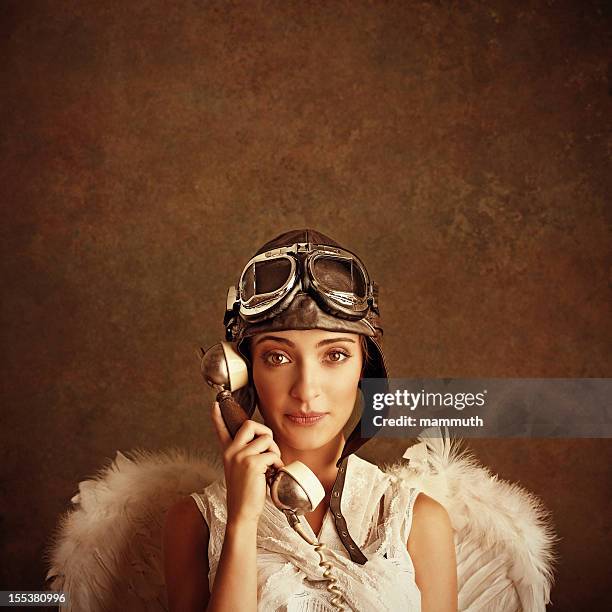 angel wearing pilot helmet and goggles talking on the phone - flying goggles stockfoto's en -beelden