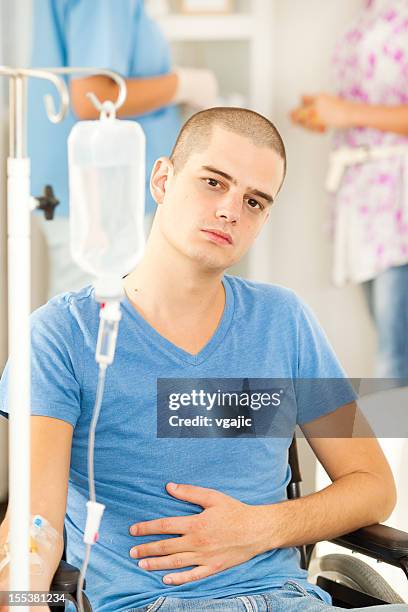 young man receiving chemotherapy at home. - chemotherapy man stock pictures, royalty-free photos & images