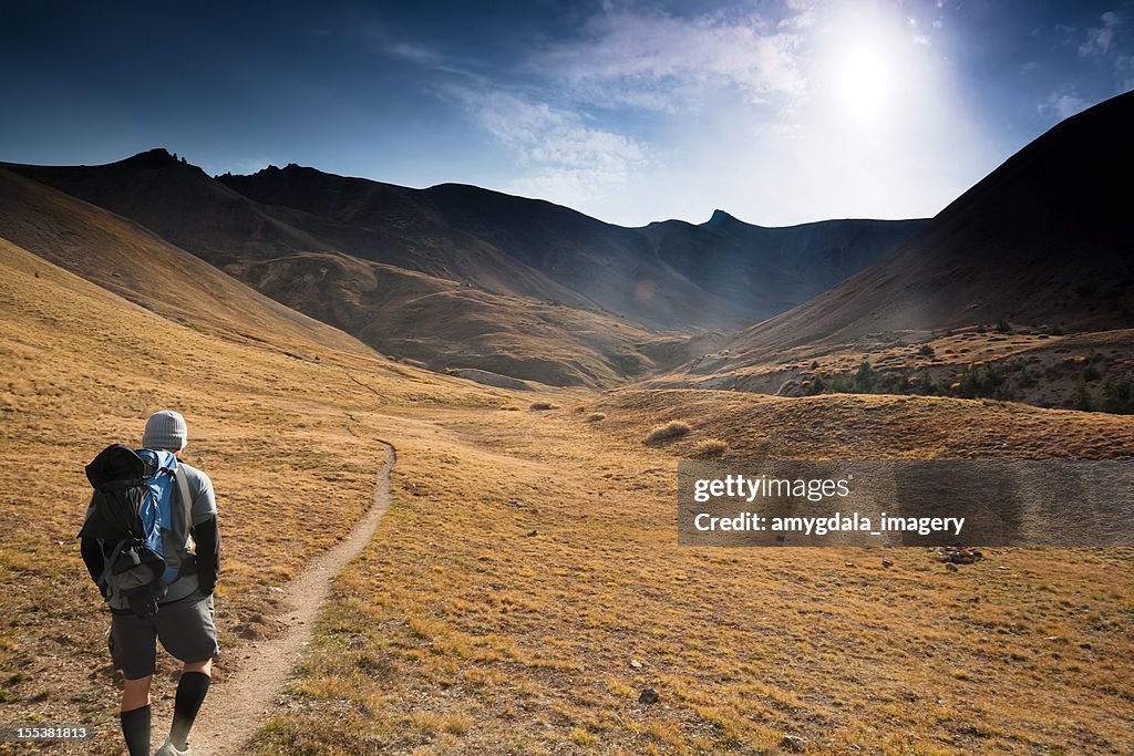 Homem de caminhadas sol paisagem de montanhas