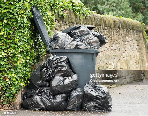 overflowing wheelie bin - garbage pile stock pictures, royalty-free photos & images