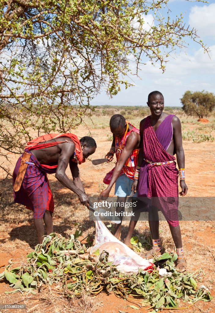 Giovane masai guerriero macellazione una capra.