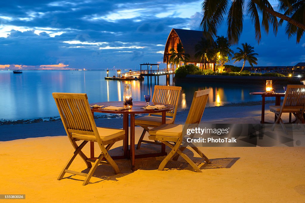 Cena romántica a la luz de las velas en el restaurante junto a la playa