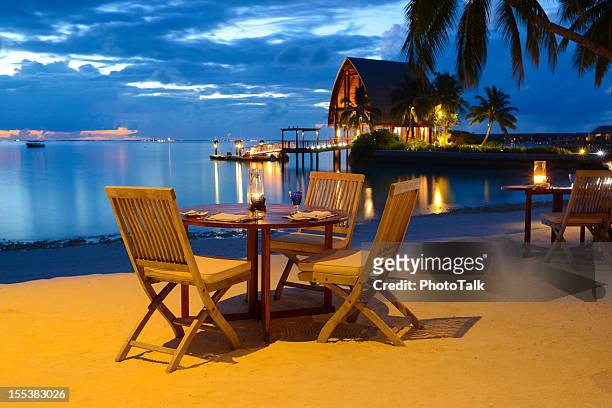 romantic candlelight beach dinner at seaside restaurant - evening meal restaurant stock pictures, royalty-free photos & images