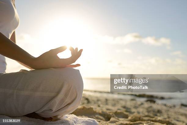 woman sitting on beach with yoga lotus position - foreign born stock pictures, royalty-free photos & images