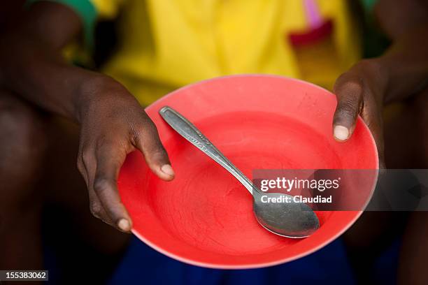 african child holds empty plate - hungry stock pictures, royalty-free photos & images