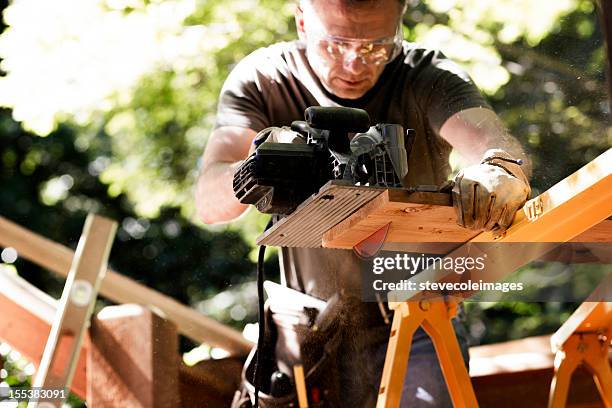 carpenter cutting wooden plank with circular saw. - saw blade stock pictures, royalty-free photos & images