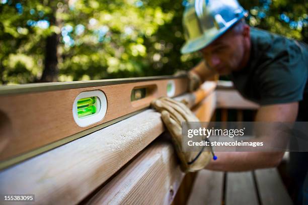 male carpenter working with spirit level. - spirit level stock pictures, royalty-free photos & images