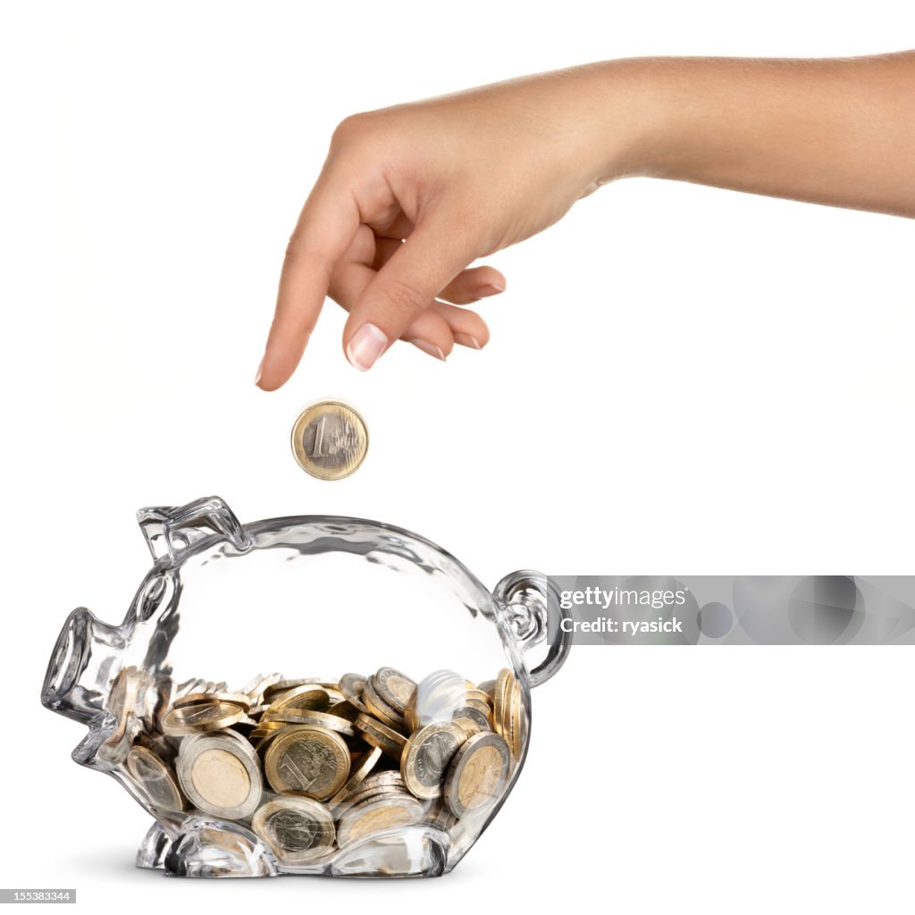 Female Hand Dropping Euro into Half Full Piggy Bank