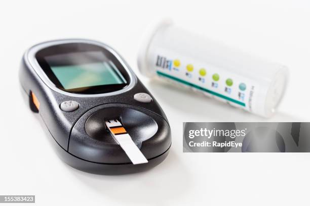 diabético equipo: glucómetro con tira de la prueba de glucemia inserta - glucómetro fotografías e imágenes de stock