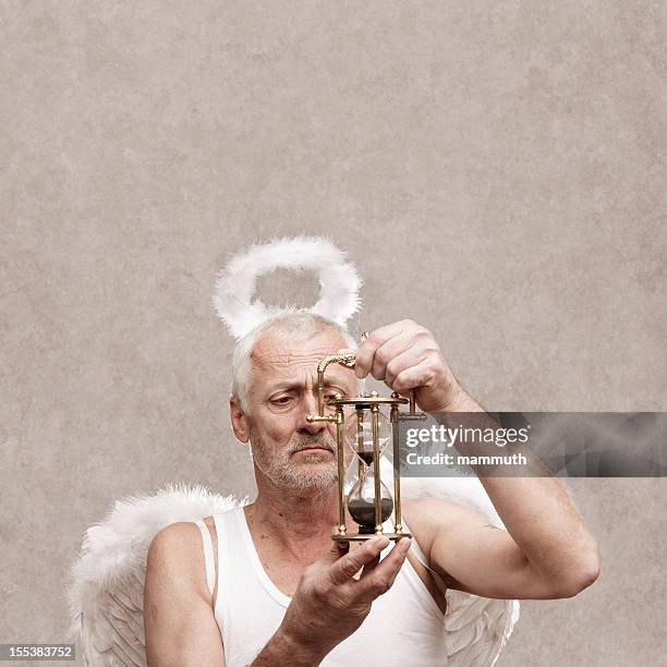 senior male angel looking at a hourglass - costume wing stock pictures, royalty-free photos & images