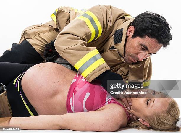 pregnant woman being help by a fireman - coma stock pictures, royalty-free photos & images