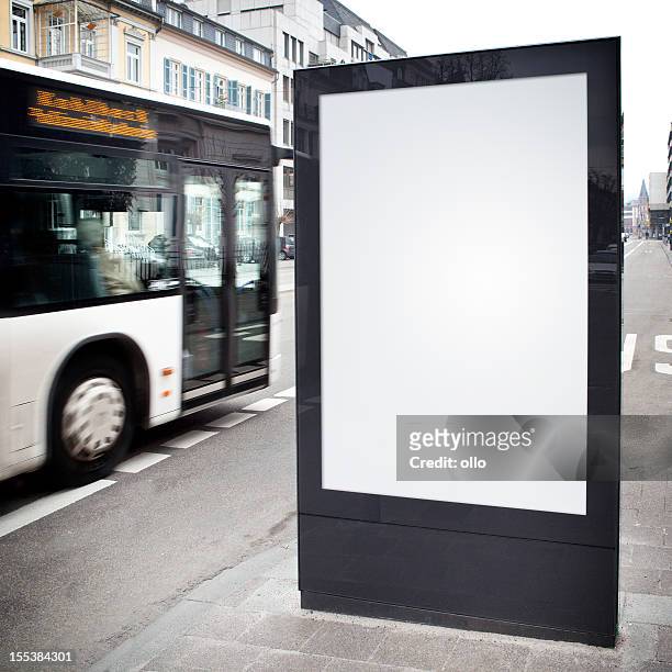 blank advertising billboard on city street, bus passes - billboard bus stockfoto's en -beelden