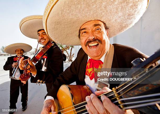 three smiling members of a mariachi band - mariachi band stockfoto's en -beelden