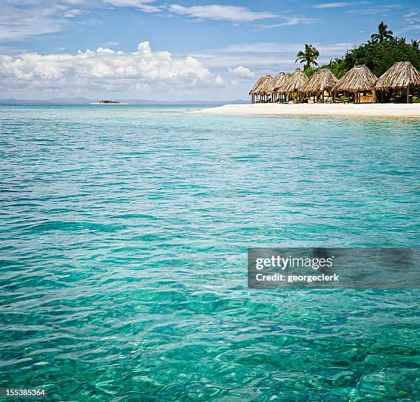 island resort from the sea - thatched roof huts stock pictures, royalty-free photos & images