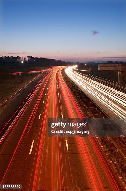 busy motorway traffic trails at dusk - motorway uk stock pictures, royalty-free photos & images