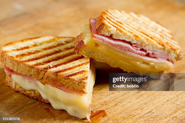 sliced panini sandwich on wood surface - grilled cheese stock pictures, royalty-free photos & images