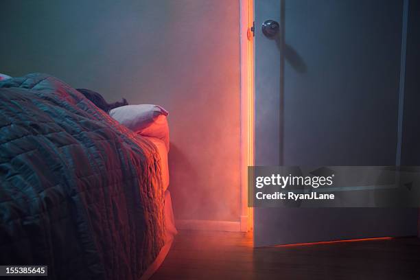 fire visible through bedroom door - person-opening-door stock pictures, royalty-free photos & images