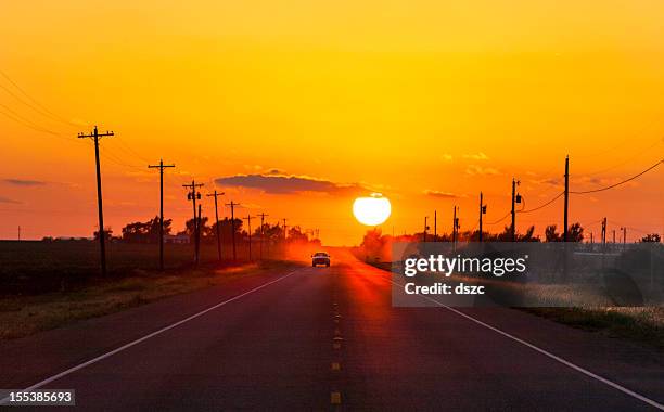 pickup truck at sunset on country road oeste de texas - car road sunset fotografías e imágenes de stock