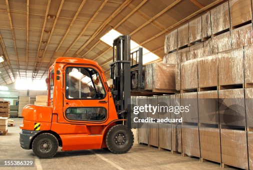 Forklift operator loading boxes in warehouse Forklift operator loading boxes in warehouse