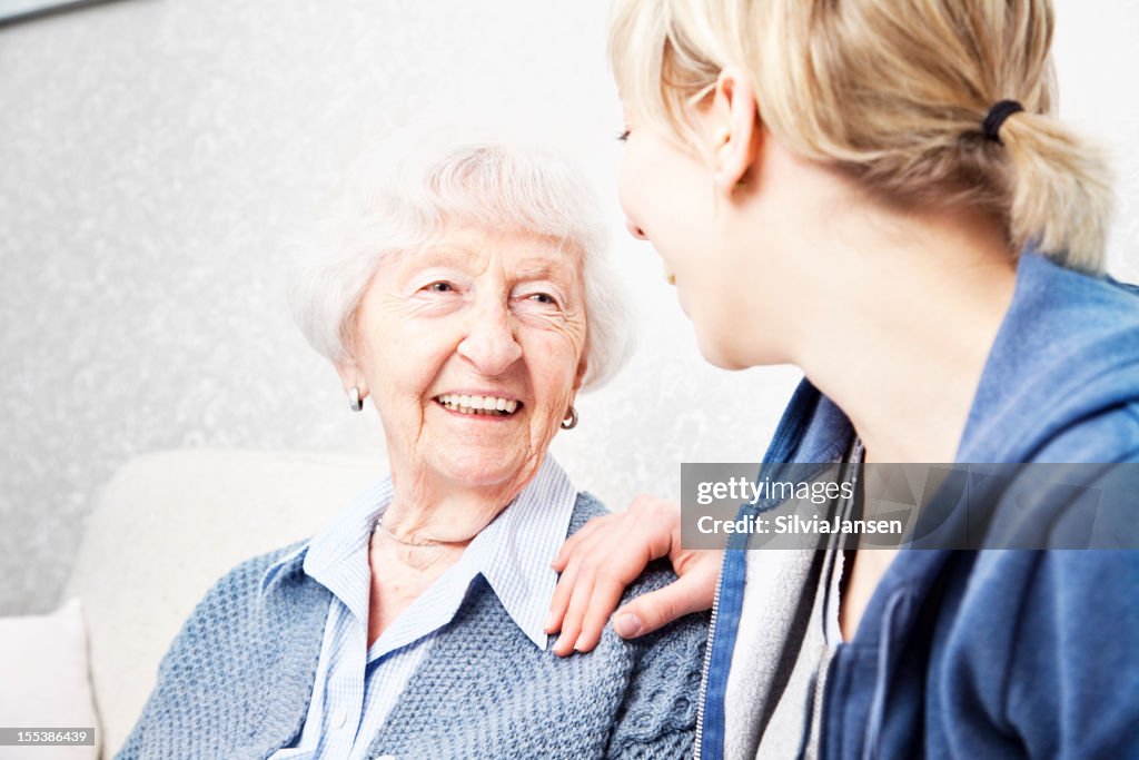 Home caregiver talking with senior woman