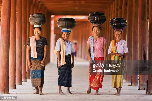 burmese women carrying bowls of rice to the monastery - myanmar stock pictures, royalty-free photos & images