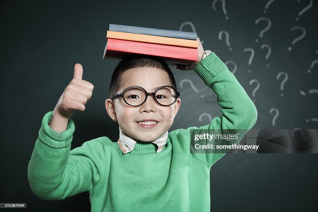 One boy stands in front of the blackboard