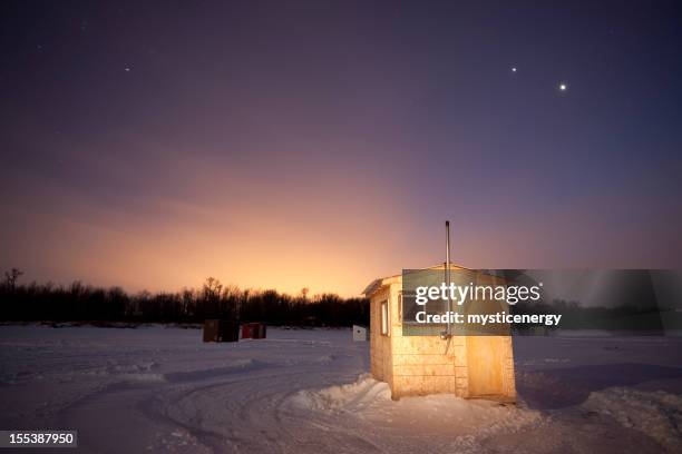 small ice fishing huts at sunset - ice fishing stock pictures, royalty-free photos & images