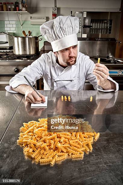 young chef fusilli pasta quality control - goatee stockfoto's en -beelden