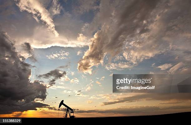 prairie pumpjack silhouette - alberta oil stock pictures, royalty-free photos & images