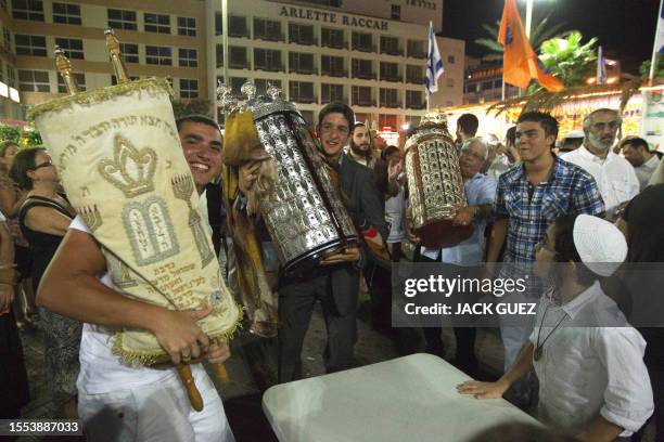 Jews dance with the Torah scrolls during the Simhat Torah celebration in the coastal city of Netanya, north of Tel Aviv on September 30, 2010. Simhat...