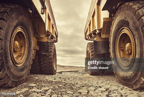 symmetrical dump trucks - vrachtwagen banden stockfoto's en -beelden