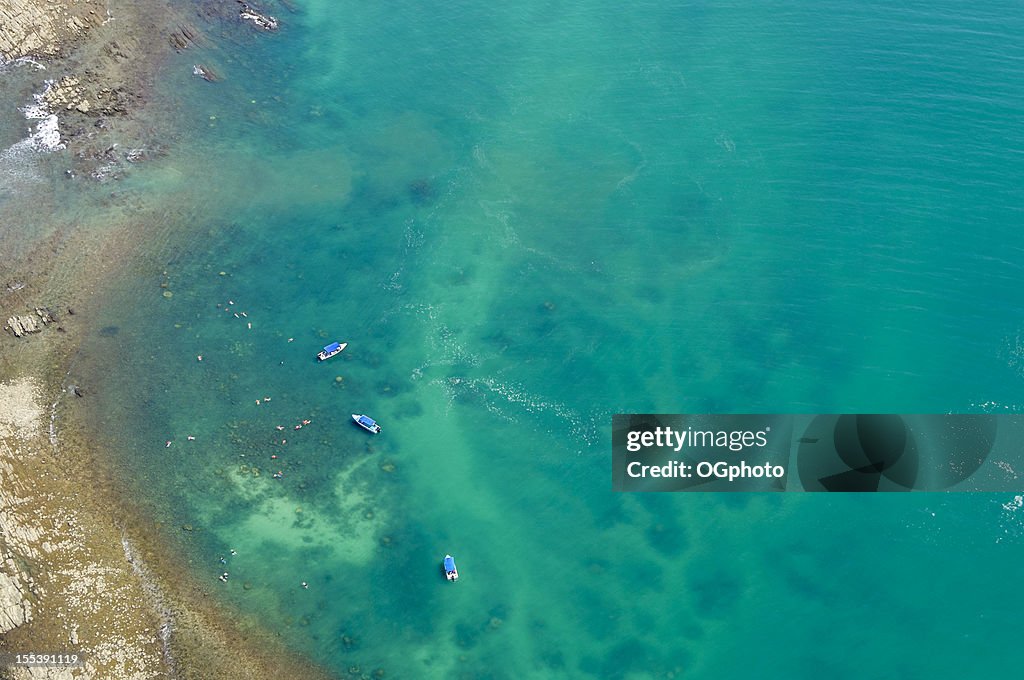 Aerial view of boats and people snorkeling